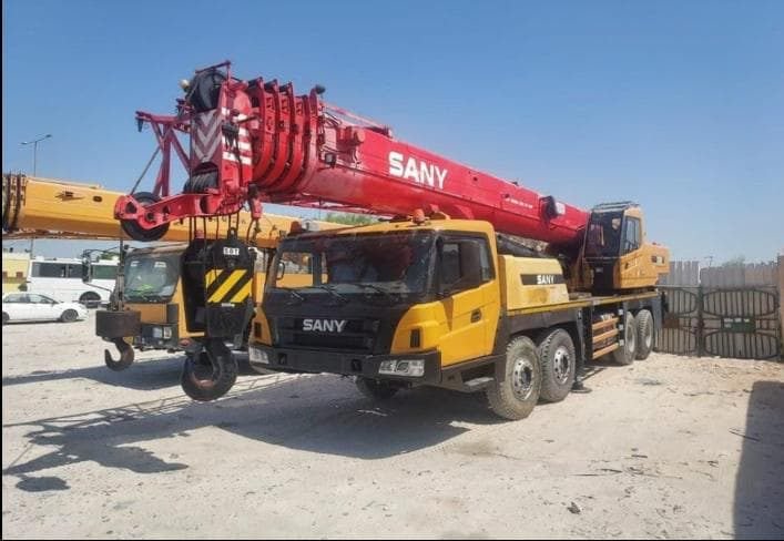 Mobile crane parked in an equipment yard, side view
