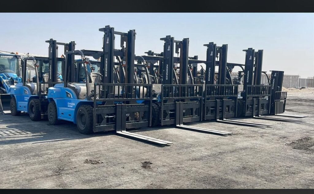 Row of forklifts parked in an outdoor equipment lot